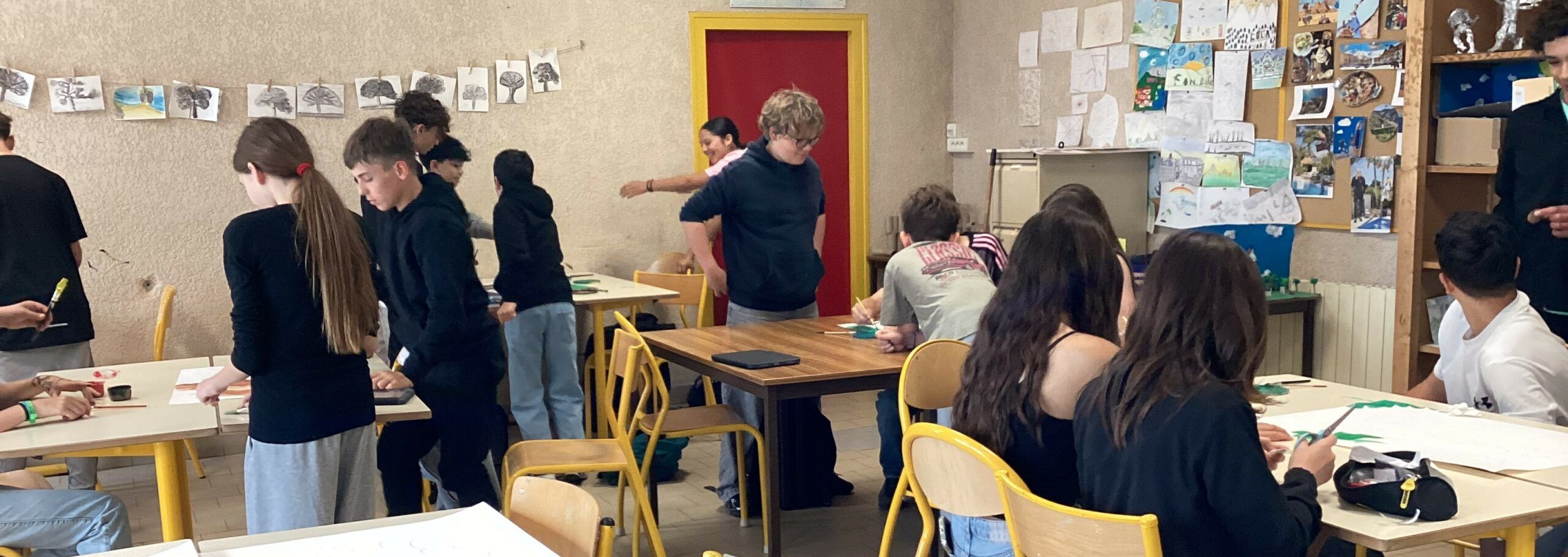 Élèves de 5ème réalisant le décor de forêt peinte pour le spectacle de théâtre.